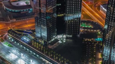 Dubai şehir merkezindeki yol kavşağında yoğun bir trafik var. Birçok araba cam gökdelenlerin yakınındaki kavşakta ilerliyor, BAE