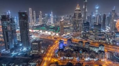 Şehir merkezinin ufuk çizgisi, modern mimari biçimle gece zamanının üstünde. Dubai iş hangarı kulelerinin hava görüntüsü. Gökdelenler ve oteller arasındaki yollarda trafik