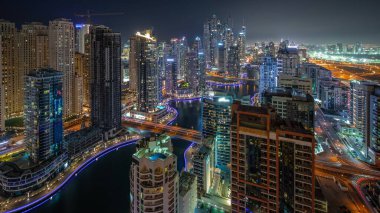 Dubai Marina hava sahasının en uzun bloğundaki çeşitli gökdelenlerin görüntüsü suni kanallı gece zaman ayarlı. Bir sürü kule ve yat. Köprülerde trafik