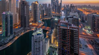 Dubai Marina hava sahasının en yüksek bloğundaki çeşitli gökdelenlerin görüntüsü suni kanallı panoramik zaman geçişi. JBR ilçesinde birçok kule ve yat gün doğumundan önce