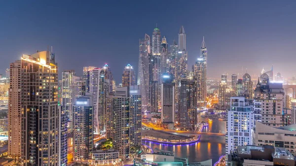 通过人工运河 从天到晚俯瞰迪拜码头最高交点区的各种摩天大楼 日落后的许多塔楼和游艇 — 图库照片