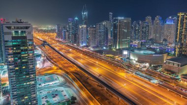 Dubai Marina gökdelenleri ve Şeyh Zayed yolu ile metro demiryolu hava akımının zaman çizelgesi. Modern kulelerin yakınındaki bir otoyolda trafik var, Birleşik Arap Emirlikleri.