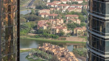 JLT semt gökdelenleri ile park zamanı olan yapay göl arasındaki konut geliştirme alanının havadan görüntüsü. Çimenli ve göletli Dubai manzarası