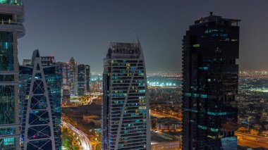 Dubai çok amaçlı emtialar merkezi karma kullanım bölgesinin bir parçası olan JLT hava sahasındaki uzun konut binaları. Arka planda villalar ve yol trafiği