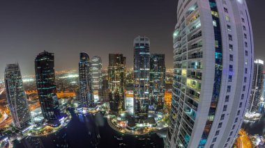 Dubai çok amaçlı emtia merkezi karma kullanım bölgesinin bir parçası olan JLT ilçe hava sahasındaki yüksek konut binalarının panoraması. Göl kenarındaki gökdelenler