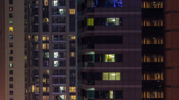 Night view of lights in panoramic windows of multistory buildings aerial timelapse. Illuminated skyscraper in a big city