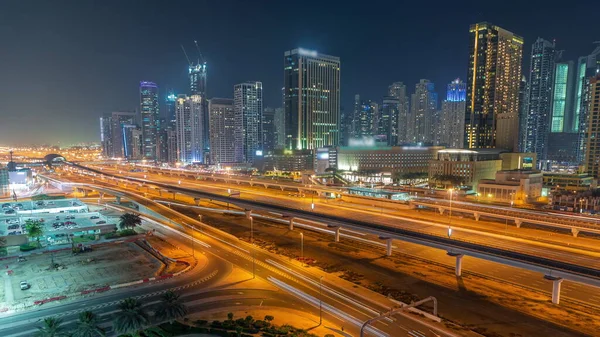 ドバイ マリーナの高層ビルやシェイク ザイード通りには地下鉄の夜間空路がある 近代的な塔やショッピングモールの近くの高速道路での交通 アラブ首長国連邦 — ストック写真