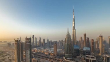 Dubai şehir merkezindeki en yüksek kulelerin panoramik hava manzarası ve karayolu zaman çizelgesi. Gündoğumunda akıllı kentlerdeki finans bölgesi ve iş sahası