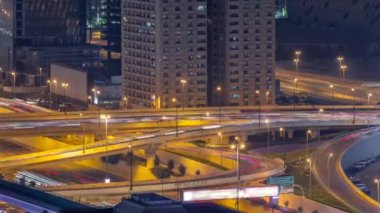 Büyük otoyol kavşağı ve Dubai su kanalı. Arka planda yaya köprüsü var. İnşaat alanında da vinçler var. Birçok ev ve villa kavşağın arkasında..