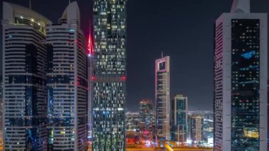 Dubai Uluslararası Finans Bölgesi 'nin birçok gökdelenli gece görüşü. Metro istasyonunun yakınındaki bir yolda trafik vardı. Dubai, BAE.