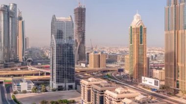 Dubai şehrinin ufuk çizgisi panoramik manzaralı metro ve araçlar şehrin en işlek otoban sabah saatlerinde hareket ediyor. Gökdelenlerle çevrili bir kavşak