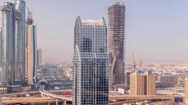 Dubai şehrinin ufuk çizgisi panoramik manzaralı metro ve arabaların hareket halindeki şehirleri en işlek otoban zaman çizelgesi. Gökdelenler ve inşaat alanlarıyla çevrili bir kavşak.