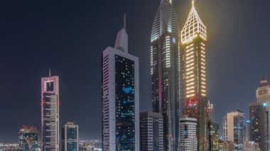 Dubai Uluslararası Finans Bölgesi 'nin tüm gece boyunca birçok gökdeleni ve ışıkları kapalı olan hava manzarası. Çatı yüzme havuzlu çok katlı otoparkın yakınındaki bir yolda trafik vardı.