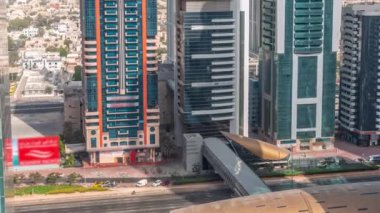 Dubai Uluslararası Finans Bölgesi 'nin birçok gökdelen zaman ayarlı havadan görüntüsü. Metro istasyonunun yakınındaki bir otoyolda trafik vardı. Dubai, BAE.