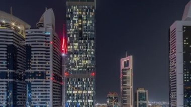 Dubai Uluslararası Finans Bölgesi 'nin birçok gökdeleni olan hava manzarası. Metro istasyonu yakınlarındaki bir yolda trafik ve çatısı yüzme havuzlu çok katlı bir otopark. Dubai, BAE.