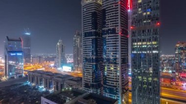 Dubai Uluslararası Finans Bölgesi 'nin tüm gece boyunca gökdelenleri olan hava manzarası. Yol kavşağında trafik vardı ve Şeyh Zayed yolunda ışıklar kapalıydı. Dubai, BAE.