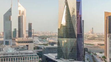 Ofis gökdelenleri zaman ayarlı Dubai Uluslararası Finans Bölgesi 'nin havadan görüntüsü. Gün batımında cam kuleden yansıyan trafik ve güneş. Dubai, BAE.