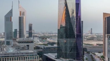 Günbatımından sonra Dubai Uluslararası Finans Bölgesi 'nin hava görüntüsü ve birçok gökdelen gece gündüz geçiş zamanı. Alışveriş caddesi ve ofis kulelerinin yakınındaki bir yolda trafik vardı. Dubai, BAE.