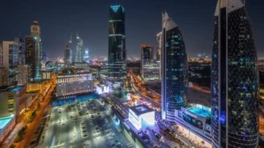 Dubai Uluslararası Finans Bölgesi 'nin birçok gökdeleni ve panoramik zaman çizelgesi olan havadan görüntüsü. Alışveriş merkezinin otoparkının yakınındaki bir yolda trafik vardı. Dubai, BAE.