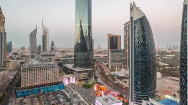 Dubai Uluslararası Finansal Bölgesi 'nin hava panoramik görüntüsü. Gün batımından sonra gece birçok gökdelen geçiş zamanı var. Alışveriş caddesi yürüme alanındaki otoparkın yanındaki yolda trafik vardı.