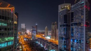 Dubai Uluslararası Finans Bölgesi 'nin birçok gökdelenli gece görüşü. Yol kavşağında trafik ve ofis kulelerinde parlayan pencereler. Dubai, BAE.