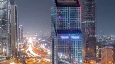 Dubai şehrinin ufuk çizgisi panoramik manzaralı metro ve arabalar tüm gece boyunca en yoğun otoban anteninde hareket halindedir. Işıklar sönmüş gökdelenlerle çevrili kavşak.