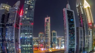 Dubai Uluslararası Finans Bölgesi 'nin Panorama' sı tüm gece boyunca birçok gökdelenle birlikte. Bir karayolu trafiği ve ışıkların söndüğü aydınlık kuleler. Dubai, BAE.