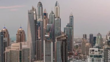 Dubai Marina hava sahasının en yüksek bloğundaki çeşitli gökdelenlerin görüntüsü suni kanalla gündüz gece geçiş zamanı. Gün batımından sonra birçok kule ve yat