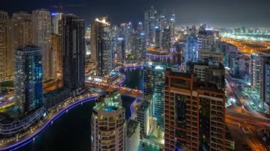 Dubai Marina hava sahasının en uzun bloğundaki çeşitli gökdelenlerin görüntüsü suni kanallı gece zaman ayarlı. Bir sürü kule ve yat. Köprülerde trafik