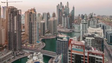 Dubai Marina hava sahasının en yüksek bloğundaki çeşitli gökdelenlerin görüntüsü günden geceye yapay kanal ve köprülerle geçiş zamanı. Gün batımından sonra birçok kule ve yat