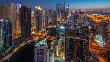 Dubai Marina hava sahasının en yüksek bloğundaki çeşitli gökdelenlerin görüntüsü suni kanallı panoramik zaman geçişi. JBR ilçesinde birçok kule ve yat gün doğumundan önce