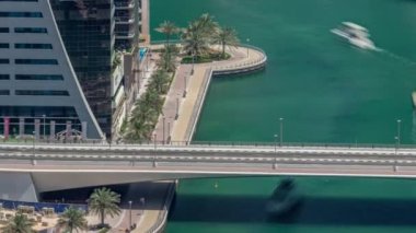 Dubai Marina Rıhtımı ve şehir gezinti zamanı yukarıdan. Kanallar boyunca gökdelenlerin havadan görüntüsü. Köprünün altında yüzen yatlar