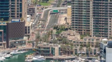 Dubai Marina Rıhtımı ve şehir gezinti zamanı yukarıdan. Kanallar boyunca gökdelenlerin havadan görüntüsü. Bir yol kavşağında trafik