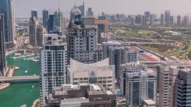 Dubai lüks bir semt ve golf kulübü zaman dilimi. Kanal boyunca Dubai marina gökdelenleri yakınlarındaki yeşil kulelerin ve yol kavşağının havadan panoramik görüntüsü