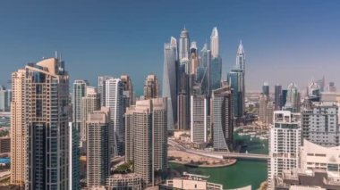 Gün batımında uzun gölgeli yapay kanallarla Dubai Marina 'nın en yüksek karşılama bloğundaki çeşitli gökdelenlerin görüntüsü. Pek çok kule ve yat