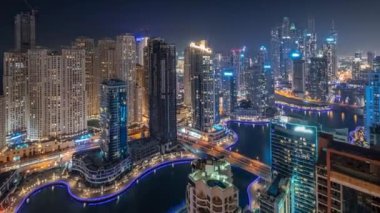 Dubai Marina hava sahasının en uzun bloğundaki çeşitli gökdelenlerin görüntüsü suni kanallı gece zaman ayarlı. Pencereleri ve yatları yanıp sönen bir sürü kule var.