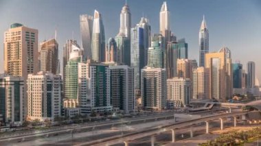 Dubai marinası gökdelenlerin en yüksek binası. JLT bölgesinden apartman binalarına, otellere ve iş kulelerine hava manzarası. Otoyolda trafik vardı.