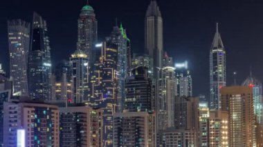 Dubai marinası tüm gece boyunca gökdelenlerin en yüksek binası ve ışıkları kapalı. JLT bölgesinden apartman binalarına, otellere ve otoyol yakınlarındaki iş kulelerine hava manzarası.