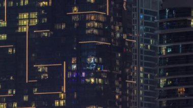 Çok katlı binaların panoramik pencerelerindeki gece görüşü hava zaman ayarlı. Büyük bir şehirde cam kürklü gökdelenle aydınlatılmış