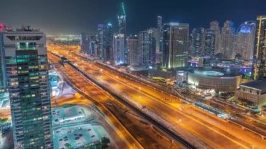 Dubai Marina gökdelenleri ve Şeyh Zayed yolu ile metro demiryolu hava akımının zaman çizelgesi. Modern kulelerin yakınındaki bir otoyolda trafik var, Birleşik Arap Emirlikleri.