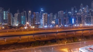 Dubai marinasının panorama 'sı tüm gece boyunca gökdelenlerin en yüksek binası ve ışıkları kapalı. JLT bölgesinden apartman binalarına, otellere ve otoyol yakınlarındaki iş kulelerine hava manzarası.