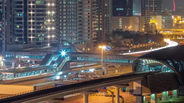 ドバイ地下鉄駅の未来的な建物とドバイマリーナ航空の夜のタイムラプスの背後にある豪華な高層ビル シェイク ザイード道路高速道路への交通 アラブ首長国連邦 — ストック動画