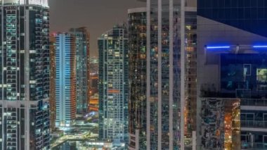 Dubai çok amaçlı emtialar merkezi karma kullanım bölgesinin bir parçası olan JLT hava sahasındaki uzun konut binaları. Kulelerin pencerelerinde parlayan ışık