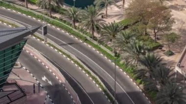 Dubai çok amaçlı emtia merkezi karma kullanım bölgesinin bir parçası olan JLT bölgesi hava zaman diliminde kavisli bir yolda trafik var. Palmiyeler göletin kıyısında