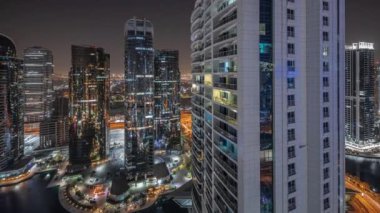 Panorama, Dubai çok amaçlı emtia merkezi karma kullanım bölgesinin bir parçası olan JLT bölgesi hava gece saatlerinde uzun konut binalarını gösteriyor. Aydınlatılmış kuleler ve gökdelenler