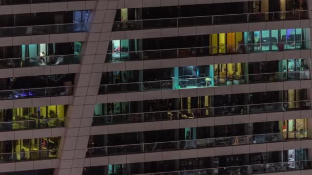 マンションの住宅タワーのタイムラプスで多くの輝く窓の夜景 高層ガラスの超高層ビルで 部屋の照明 — ストック動画