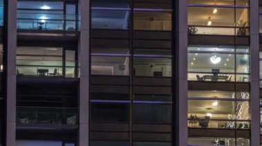 Modern ofisteki büyük parlayan pencereler ve konut binaları gece saatlerine göre ayarlanıyor, pencereler ışık saçıyor. Evde çalışma yeri