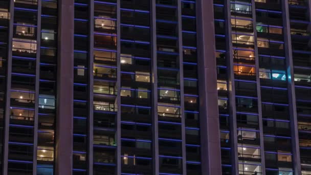 现代写字楼和住宅建筑中的巨大的发光窗户在夜晚穿行 一排排的窗户闪烁着光芒 许多街区的公寓 — 图库视频影像