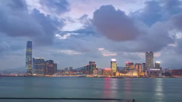 スカイラインのパノラマの時間は 香港の国際商業センターや船との昼夜の遷移から経過します 香港西九龍の高層ビルがライトアップされました — ストック動画