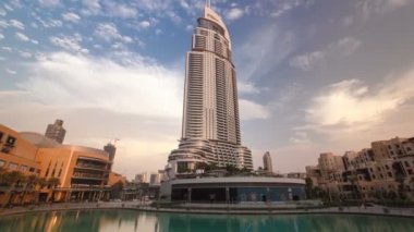 Otel Dubai kent merkezinde günbatımı zaman bulutlar ile ünlü dans çeşmeler Dubai, BAE bakar. Timelapse 4k